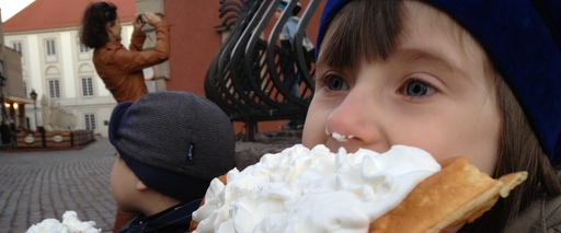 Plac Zamkowy, dzieci jedzą gofry, atrakcyjna turystka fotografuje Zamek Królewski